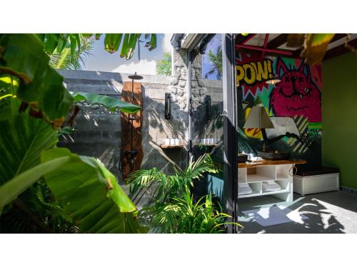 a door to a room with plants and graffiti at Oaga Art Resort Maldives - Greatest All Inclusive Plan with Free Speedboat Round-trip in North Male Atoll