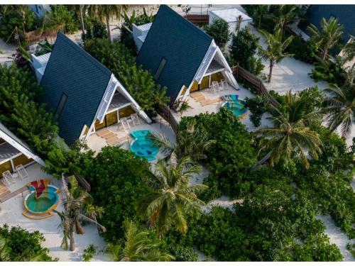 an aerial view of a resort with a pool and palm trees at Oaga Art Resort Maldives - Greatest All Inclusive Plan with Free Speedboat Round-trip in North Male Atoll