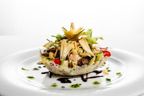 a plate of food with a salad on a white plate at Albergo La Rocca in Brisighella
