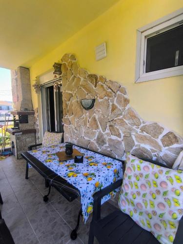 a living room with a couch and a stone wall at Blue lagoon in Skála Foúrkas