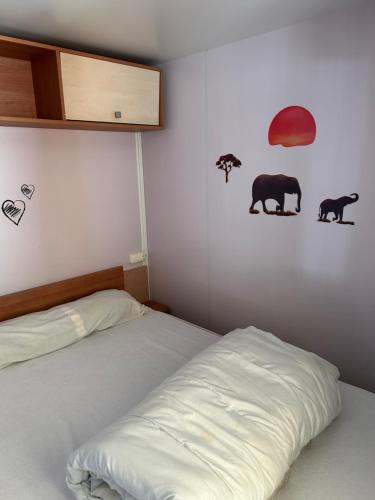 Un dormitorio con una cama y algunos animales en la pared. en Les Dunes, en Le Grau d'Agde