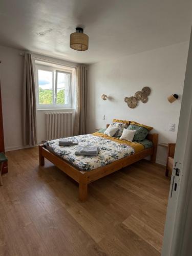 a bedroom with a bed and a window at La ferme de beau soleil Gîte et cabanes in Saint-Gilles-du-Mené