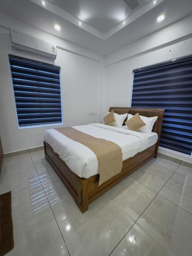卡卡纳德The Nexus Hotel Kakkanad的卧室里有一张带蓝色百叶窗的大床