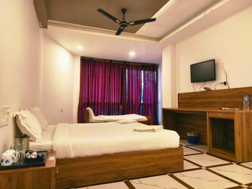 a bedroom with a bed and a television in it at Udaya Resort in Palakkad