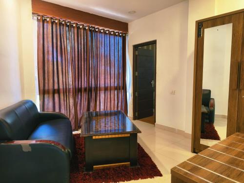 a living room with a couch and a table and a window at Udaya Resort in Palakkad