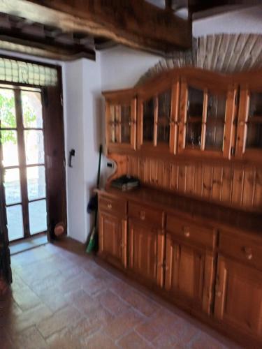 a kitchen with wooden cabinets and a sliding glass door at Agriturismo Le Case in Pietralunga