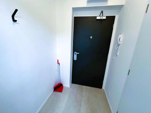 a hallway with a black door and a red umbrella at Bella Apartments Brno in Brno