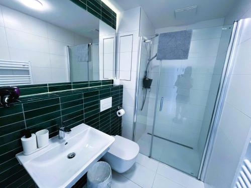 a bathroom with a sink and a shower and a toilet at Bella Apartments Brno in Brno