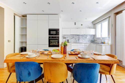 une salle à manger avec une table en bois et des chaises bleues dans l'établissement Appartement chic 82m2 6 pers Paris 16E, à Paris