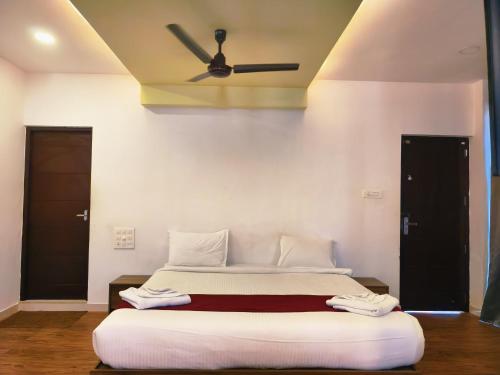 a bedroom with a bed with a ceiling fan at Udaya Resort in Palakkad