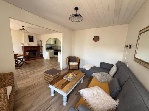 a living room with a couch and a table at La ferme de beau soleil Gîte et cabanes in Saint-Gilles-du-Mené