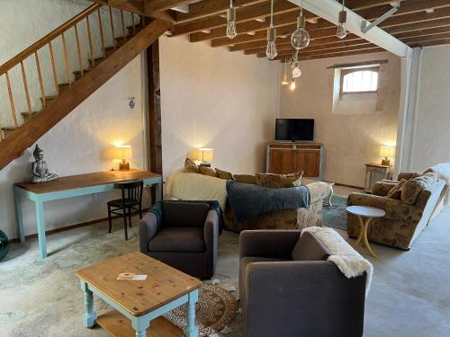 a living room with a couch and a table at La Maison du Coeur Calme in Cancon