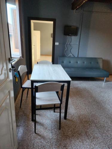 a table and chairs in a living room with a couch at Affittacamere LA BOUGANVILLE in Vigatto