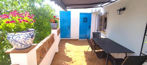 a patio with blue doors and a table and chairs at El Carmen de Sexi in Almuñécar