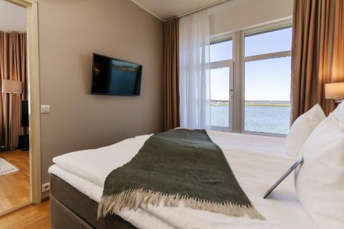 a hotel room with a bed with a large window at Hestia Hotel Haapsalu SPA in Haapsalu