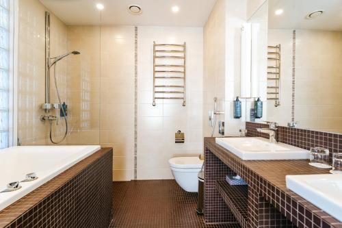 a bathroom with a tub and a toilet and a sink at Hestia Hotel Haapsalu SPA in Haapsalu