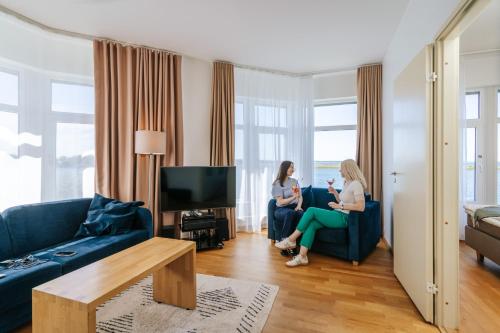 two women are sitting in a living room at Hestia Hotel Haapsalu SPA in Haapsalu