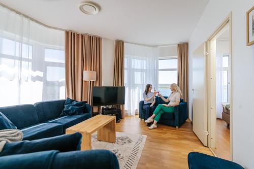 two women sitting in chairs in a living room at Hestia Hotel Haapsalu SPA in Haapsalu