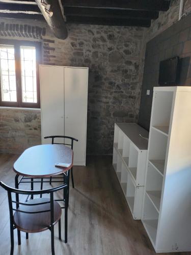 a room with a table and chairs and white cabinets at Affittacamere LA BOUGANVILLE in Vigatto