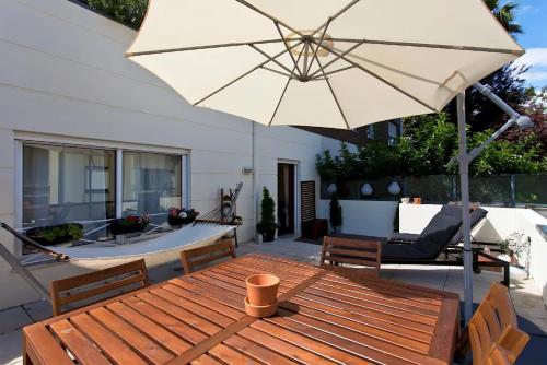 a patio with a table and an umbrella at Premium Apartment with Private Terrace & Garage in Porto