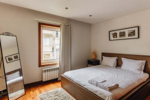 a bedroom with a bed with a mirror and a window at Premium Apartment with Private Terrace & Garage in Porto