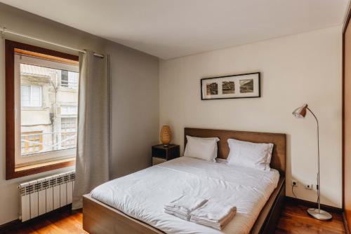 a bedroom with a bed and a window at Premium Apartment with Private Terrace & Garage in Porto