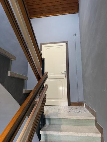 a stairway with a white door in a room at Affittacamere LA BOUGANVILLE in Vigatto