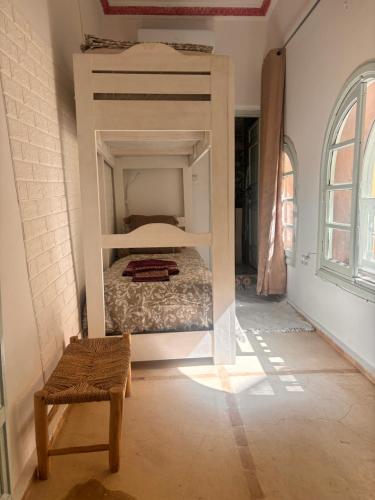 a bedroom with a bunk bed and a chair at Riad Sanwa in Marrakech