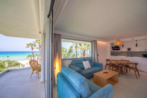 a living room with a couch and a table with a view of the ocean at Playa Esperanza Resort Affiliated by Meliá in Playa de Muro