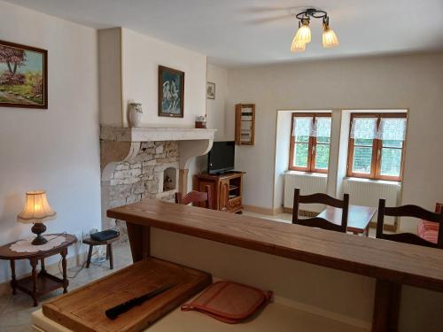 a living room with a table and a fireplace at Maison vacances 4 personnes in Mont-Saint-Jean