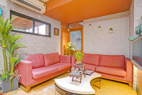 a living room with two red couches and a table at FabHotel Siddharth Inn - Nr Siddharth Bunglows in Gandhinagar