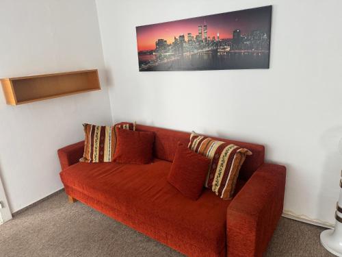 a red couch with pillows in a room at Retro domeček Dolany u kruháče in Dolany
