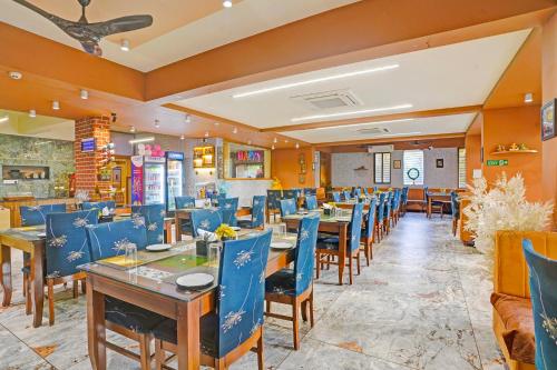 a restaurant with blue chairs and tables in it at FabHotel Siddharth Inn - Nr Siddharth Bunglows in Gandhinagar