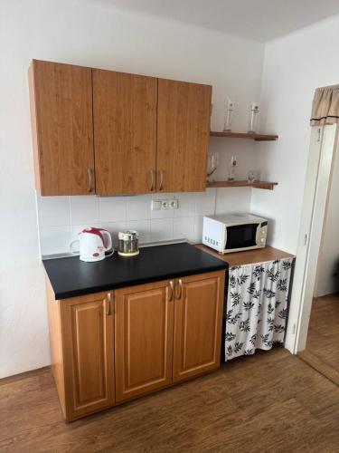 a kitchen with wooden cabinets and a black counter top at Retro domeček Dolany u kruháče in Dolany