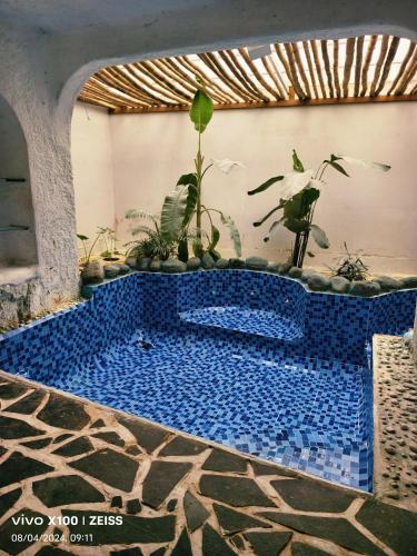 a blue tile pool with plants in a room at Udaya Resort in Palakkad