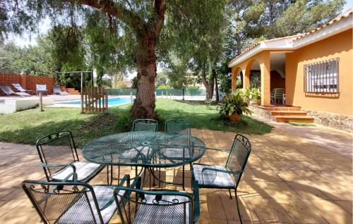 a glass table and chairs in front of a tree at Awesome Home In Bétera in Bétera