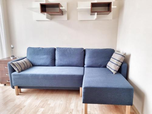 a blue couch sitting in a living room at Izabelin Apartment in Swarzędz