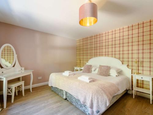 a bedroom with a bed and a desk and a mirror at 2 Bed in Sanquhar 89403 in Sanquhar