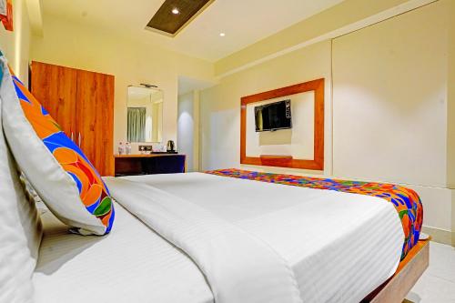 a large white bed in a room with a television at FabHotel Siddharth Inn - Nr Siddharth Bunglows in Gandhinagar