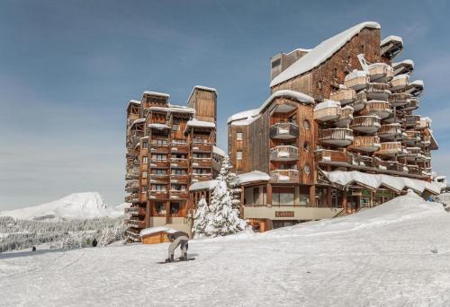 a person on a snowboard in the snow in front of a building at Résidence Saskia Falaise - Avoriaz in Avoriaz
