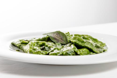 a plate of green pesto with a leaf on top at Albergo La Rocca in Brisighella