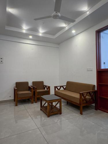 a waiting room with two chairs and a table at The Nexus Hotel Kakkanad in Kakkanad