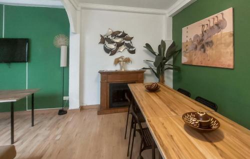 una sala da pranzo con tavolo in legno e pareti verdi di Nice Home In Jerez De La Frontera a Jerez de la Frontera