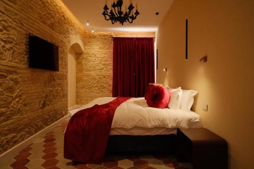 a bedroom with a bed with red pillows on it at Leano Agriresort in Piazza Armerina