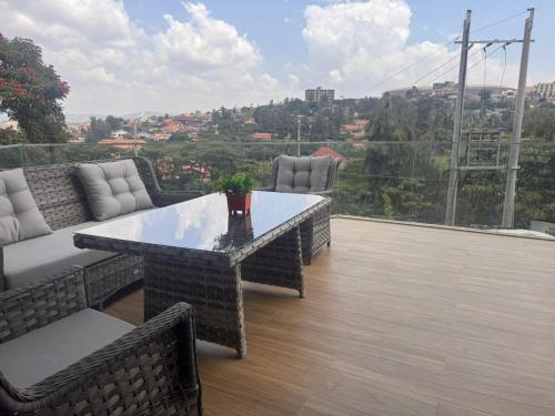 a patio with a table and chairs on a balcony at Cascadia Hotel Apartments by GF Greenland in Kigali