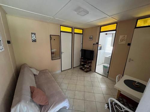 a living room with a couch and a tv at Hibiscus Apartman in Balatonfenyves