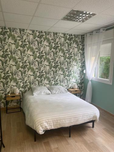 a bedroom with a bed with a green and white wallpaper at Le feuillu Bogny-sur-Meuse in Braux