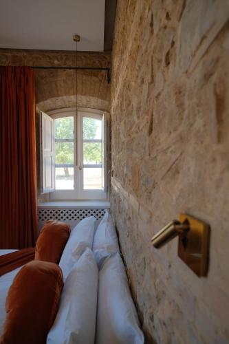 a room with a couch against a stone wall at Leano Agriresort in Piazza Armerina