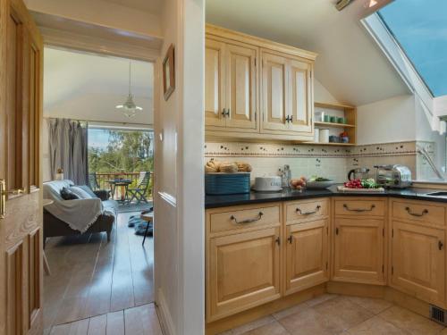 a kitchen with wooden cabinets and a dining room at 1 Bed in Coniston LCC37 in High Nibthwaite