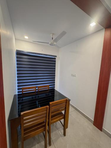 a dining room with two chairs and a table at The Nexus Hotel Kakkanad in Kakkanad
